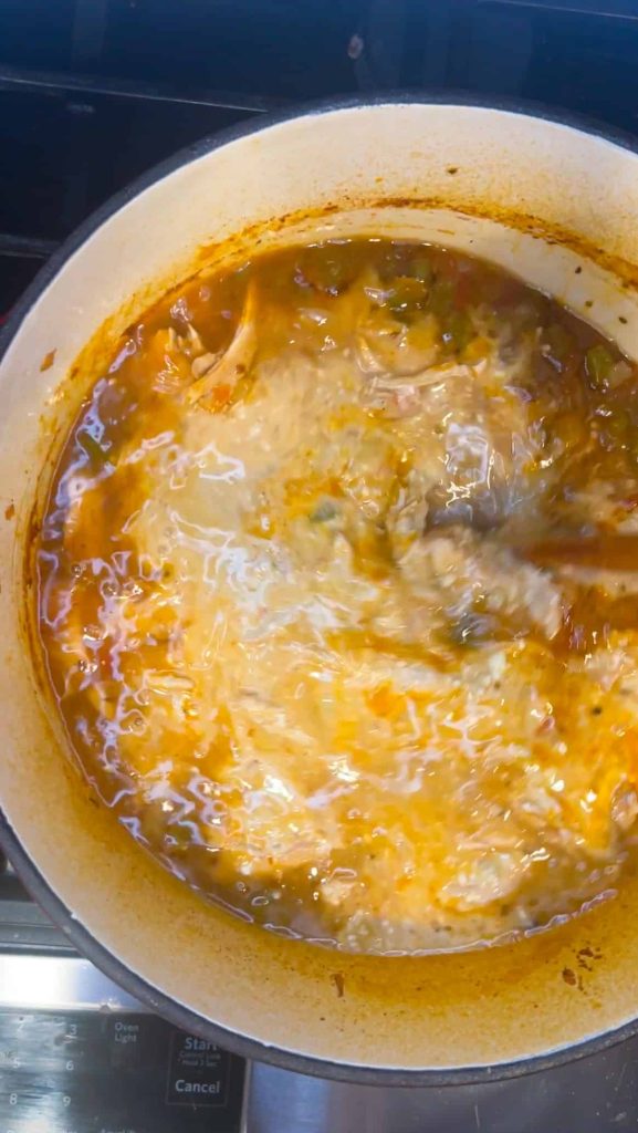 Creamy white chicken chili being stirred together in a bowl
