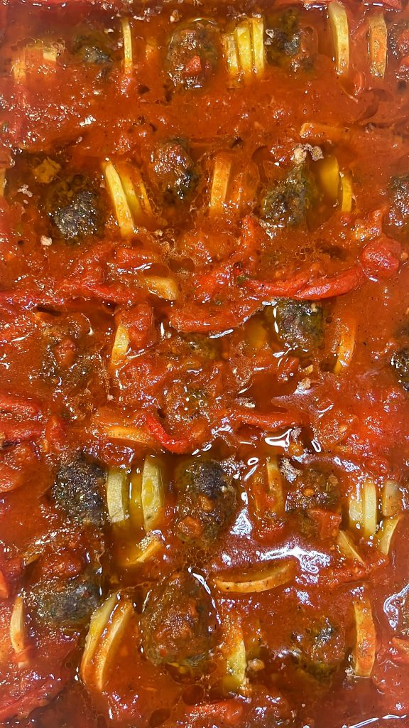 kafta bil sanieh with marinara sauce on top before baking